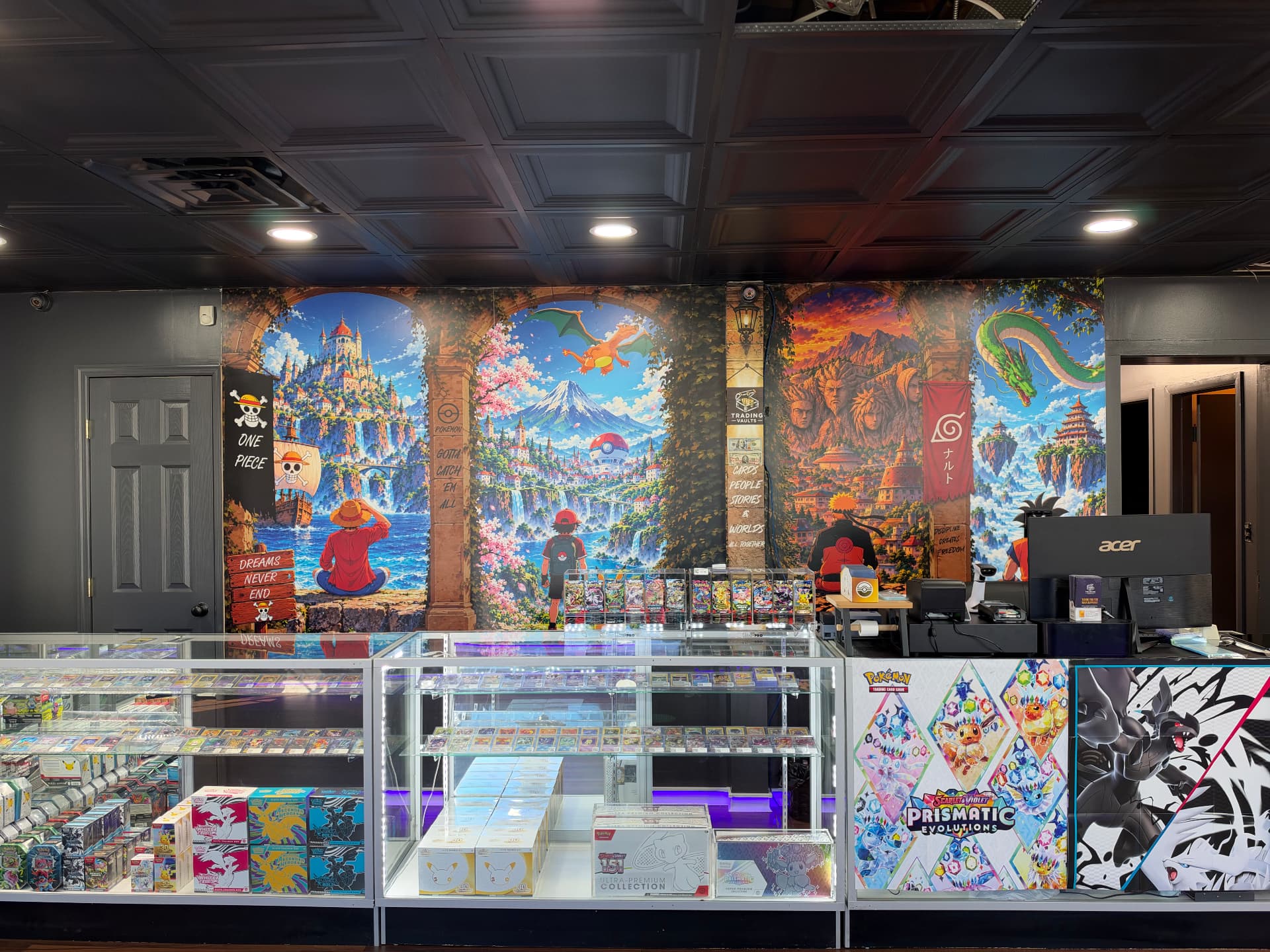 Inside Trading Vaults: glass card counters beneath the store's illustrated One Piece and Pokémon mural